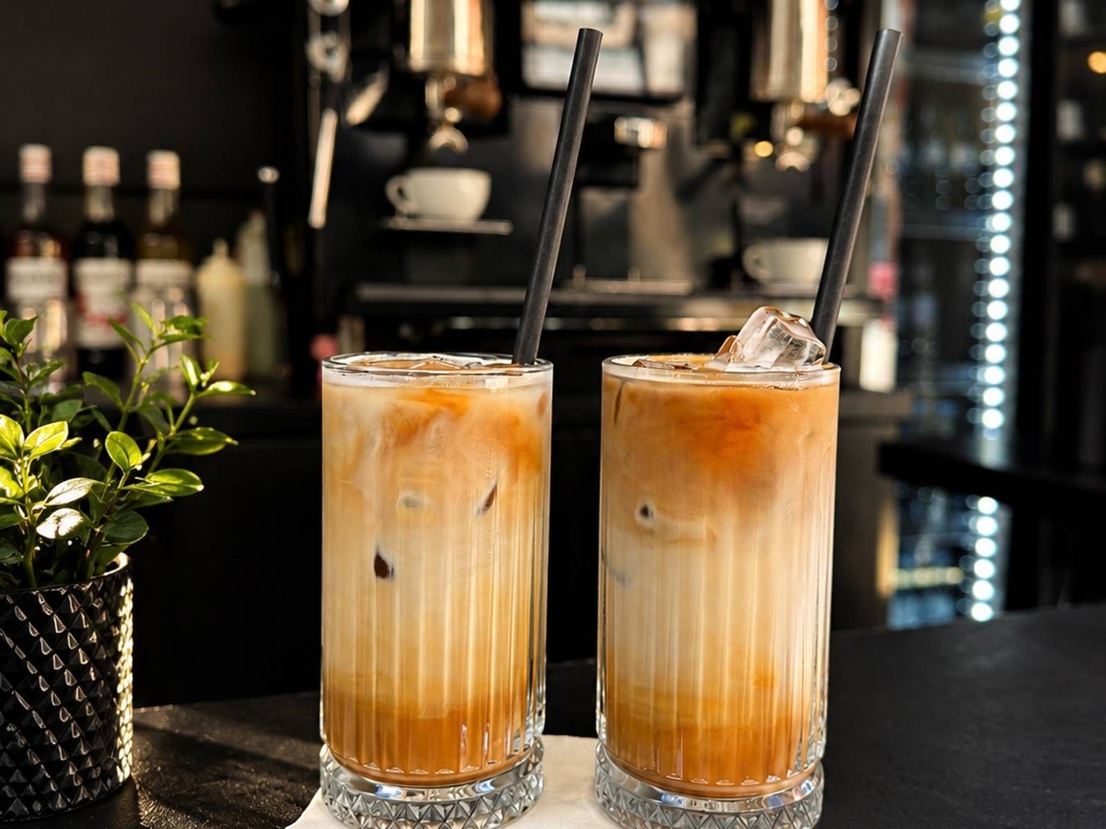 Zwei Iced Latte mit Strohhalm auf dem schwarzen Tresen des N6
