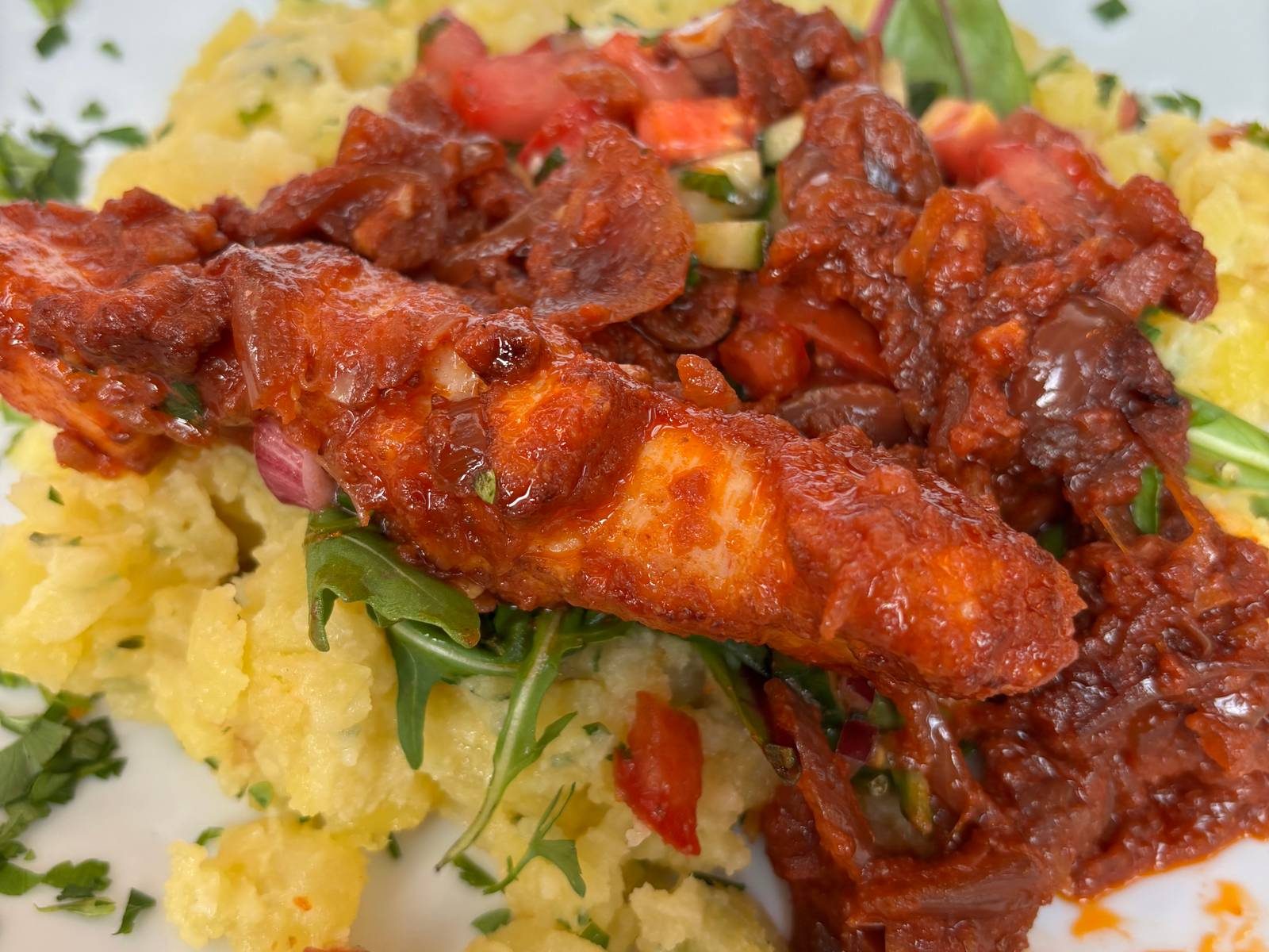 Rührei mit gebratener Sucuk, Tomaten und Kräutern auf einem Teller im N6